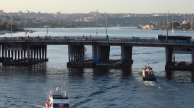 Köprünün altından geçen küçük tekneler. Köprünün üstünde ve altında hızlı trafik