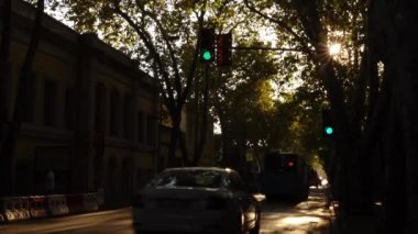 Yoğun gün trafiğinde statik zaman atlaması. Şehir trafiği, arabalar ve yayalar. Yaz batımı.