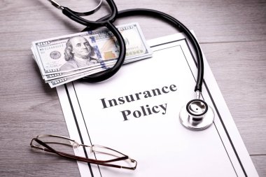Sağlık sigorta poliçesi. Stetoskop, gözlük ve dolar