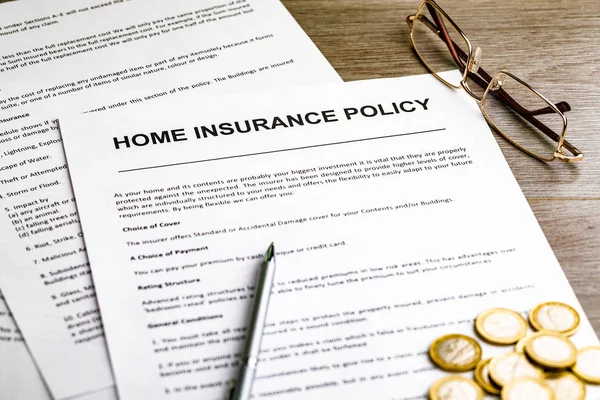 Home verzekering. Pen, glazen en een paar munten op tafel — Stockfoto