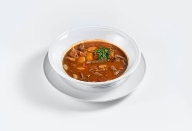 Beyaz tabakta biftek ve patates çorbası.