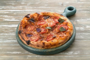 Tahta tepside domatesli ve fesleğenli lezzetli pizza.