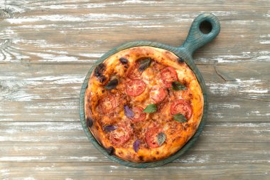 Tahta tepside domatesli ve fesleğenli lezzetli pizza.
