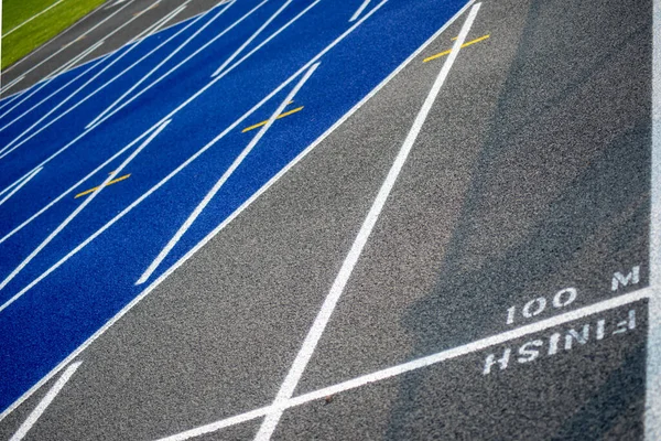 Linia mety 100 M na niebiesko-szarym torze do biegania — Zdjęcie stockowe