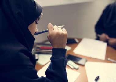 Genç Müslüman öğrenci kız evde görevleri yerine getirmeye 