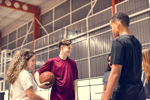 Group of teenager friends on a basketball court talking