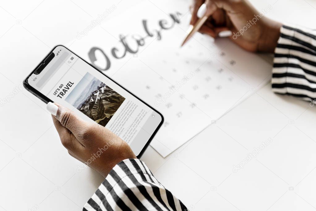 Woman scheduling on a calendar with smartphone