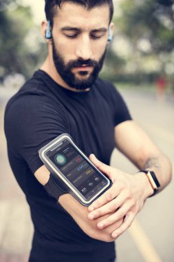 Bir smartphone kol bandı giyen bir adam