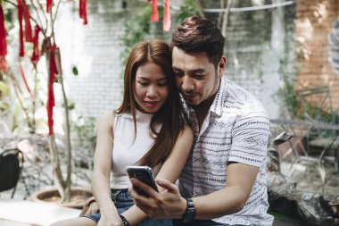 Genç çift birlikte bir telefon kullanma