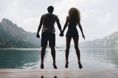 Arkadan Görünüş waterside üzerinde atlama çift