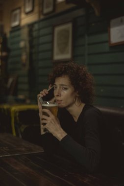 bira içip Evet barda kıvırcık saçlı kadın