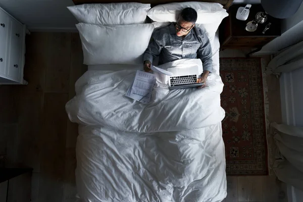 夜働くのベッドの上のビジネスの男性 — ストック写真