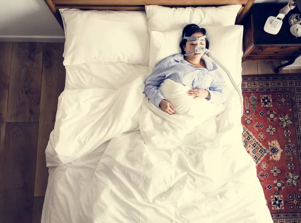 Woman sleeping with an anti-snoring mask