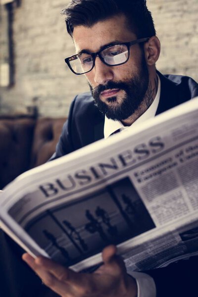 businessman in eye wear reading newspaper