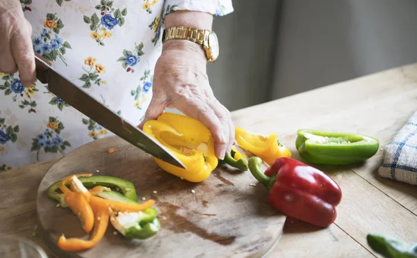 Ältere Frau Schneidet Paprika Scheiben — Stockfoto