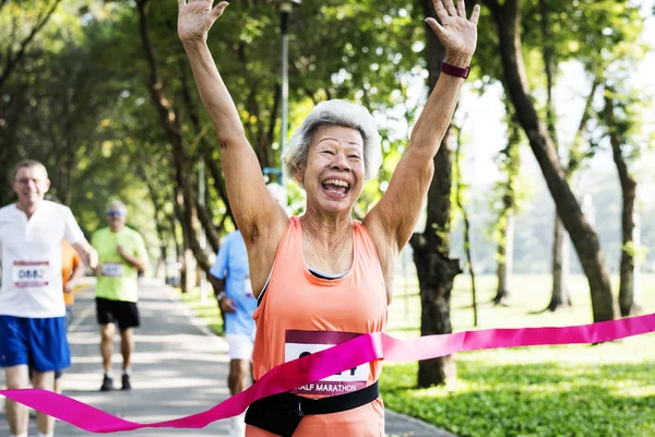 Glückliche Asiatische Frau Erreicht Ziellinie Rennende Männer Hintergrund — Stockfoto