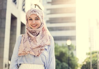 Ayakta ve şehirde gülümseyen islam kadın 