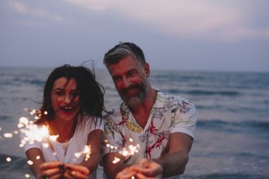 Çift sahilde havai fişekleri ile kutluyor