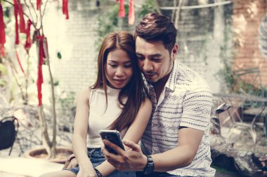 Genç çift birlikte bir telefon kullanma