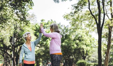 iki üst düzey sportif kadın parkta yüksek beş veren