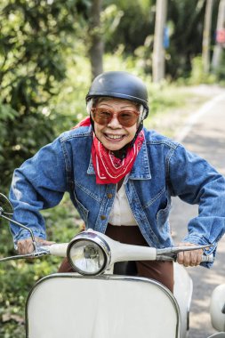 Asyalı kadın kıdemli binme klasik scooter seyahat