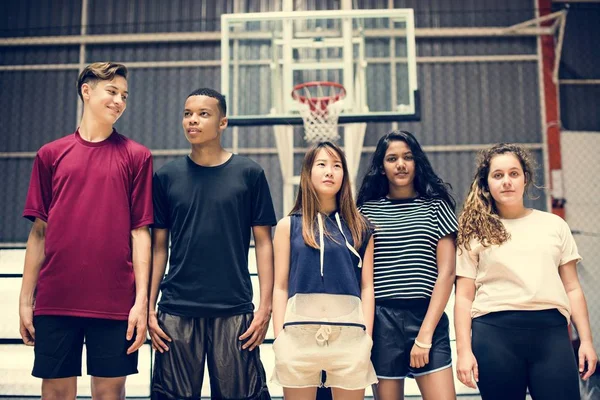 一群年轻的青少年朋友在一个篮球场站在一排 — 图库照片