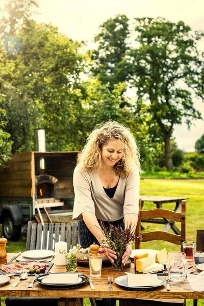 Γυναίκα Προετοιμάζει Τραπέζι Για Δείπνο Στον Κήπο — Φωτογραφία Αρχείου