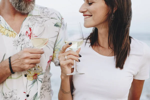 Kumsalda şarap içen çift.