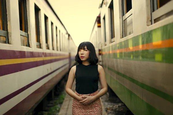 iki tren arasındaki tren istasyonunda duran güzel Asyalı kadın 