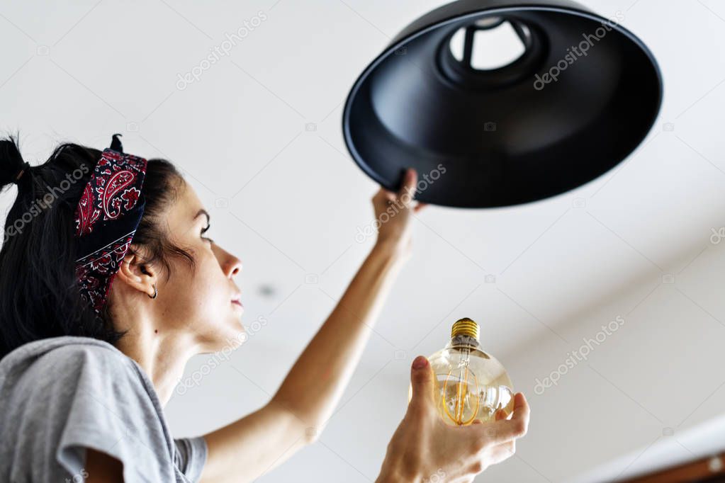 Woman changing light bulb