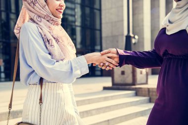 hijab açık havada el sıkışan iki islam kadın 