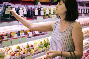 Kadın biraz üzüm süpermarkette seçme