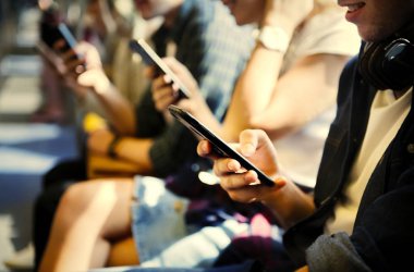 Akıllı telefonlar metroda kullanarak genç yetişkin arkadaş grubu
