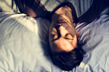 Genç çocuk yatak uykulu nap ve depresyon kavramı üzerinde uzanmış