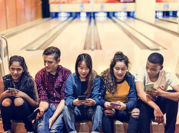 Grupo Amigos Adolescentes Usando Teléfono Inteligente Una Bolera —  Fotos de Stock
