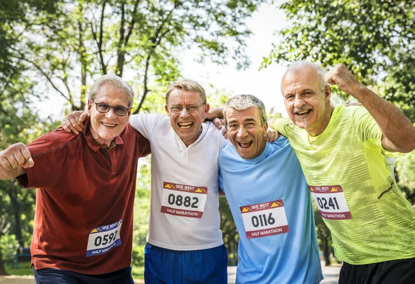 公園でマラソンを錚々 笑顔の年配の男性 — ストック写真