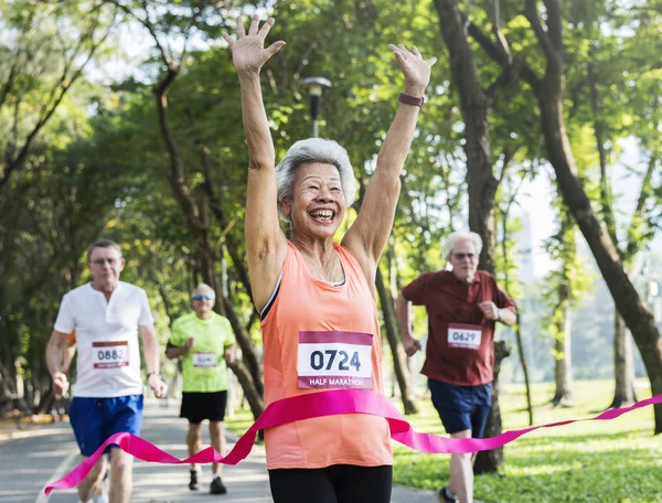 Glad Senior Kör Igenom Mållinjen — Stockfoto