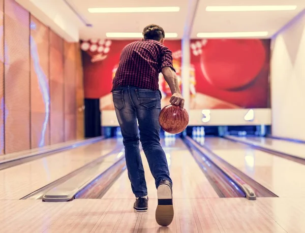 Boy about to roll a bowling ball hobby and leisure concept