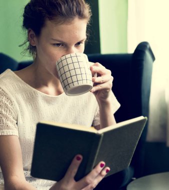 Evde kitap okuyan bir kız.