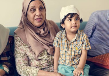 Muslim boy sitting with his grandmother clipart
