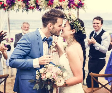 Genç çift düğün resepsiyonunda öpüşme