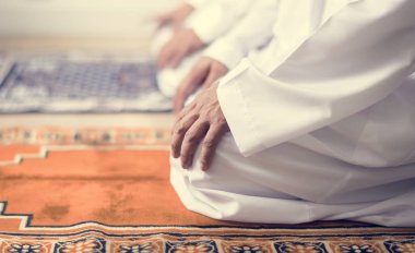 Müslüman erkeklerin dua Teşehhüt duruş, kilim üzerinde oturan insanların kırpılmış görüntü