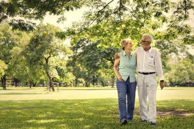 Birbirimizi parkta kucaklayan ve yürüme Olgun çift 