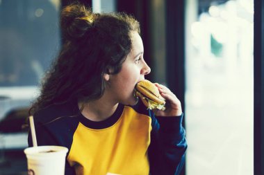Genç kız bir hamburger yeme yakın çekim