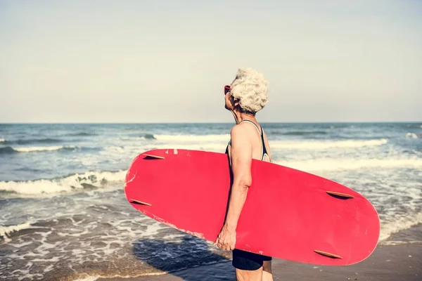 Senior Kobieta Trzymając Deskę Surfingową — Zdjęcie stockowe