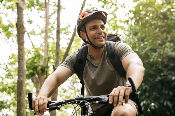 Happy cyclist riding through the forest