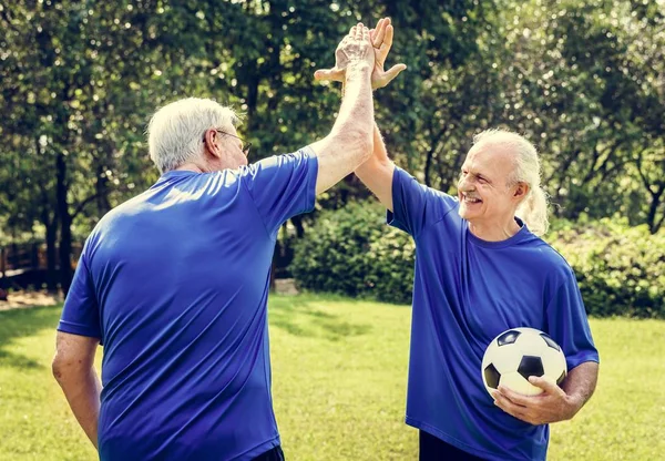 Två Senior Fotbollsspelare Ger Hög Fem Park — Stockfoto