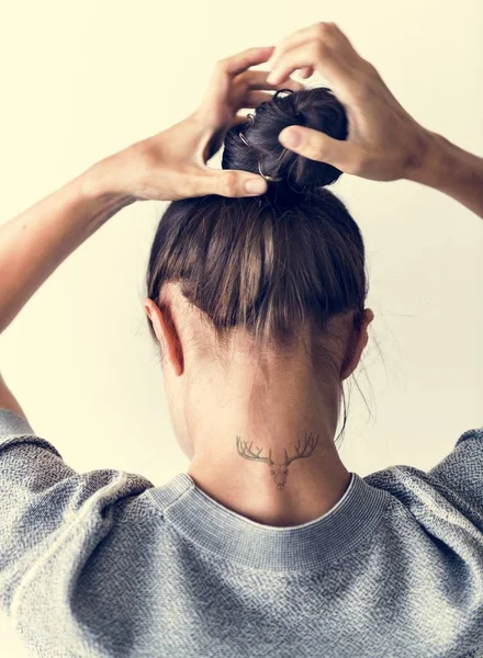 Kobieta Rozklejanie Jej Włosy Kok — Zdjęcie stockowe