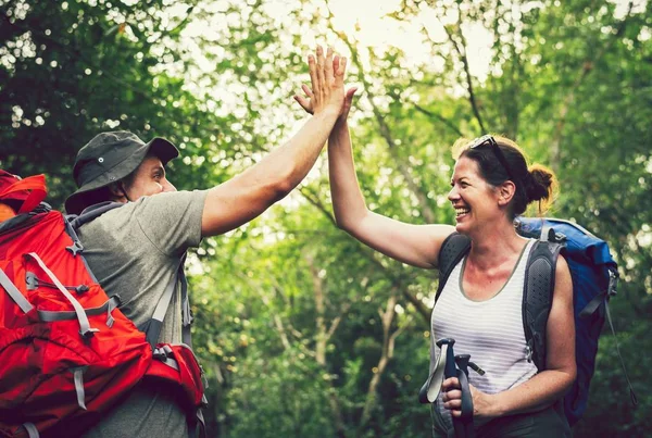 快乐的微笑夫妇给予高五 而在森林徒步旅行 — 图库照片