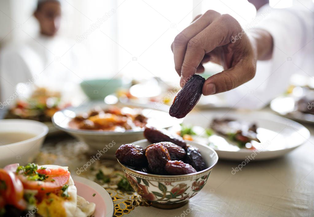 hand of man holding a date fruit at Ramadan feast